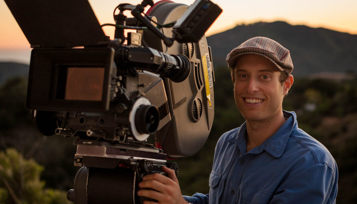 Behind the scenes of Spreading Darkness as Cinematographer Dustin Pearlman poses at sunset with the Super35mm Moviecam Compact
