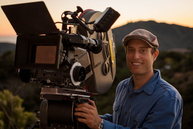 Behind the scenes of Spreading Darkness as Cinematographer Dustin Pearlman poses at sunset with the Super35mm Moviecam Compact