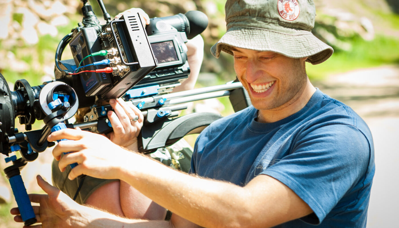 Behind the scenes of Act Naturally Cinematographer Dustin Pearlman smiling while operating HVX-200 with Letus35 Adaptor