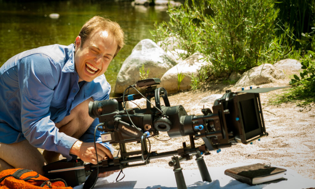 Behind the scenes of Act Naturally Cinematographer Dustin Pearlman smiling while operating HVX-200 with Letus35 Adaptor