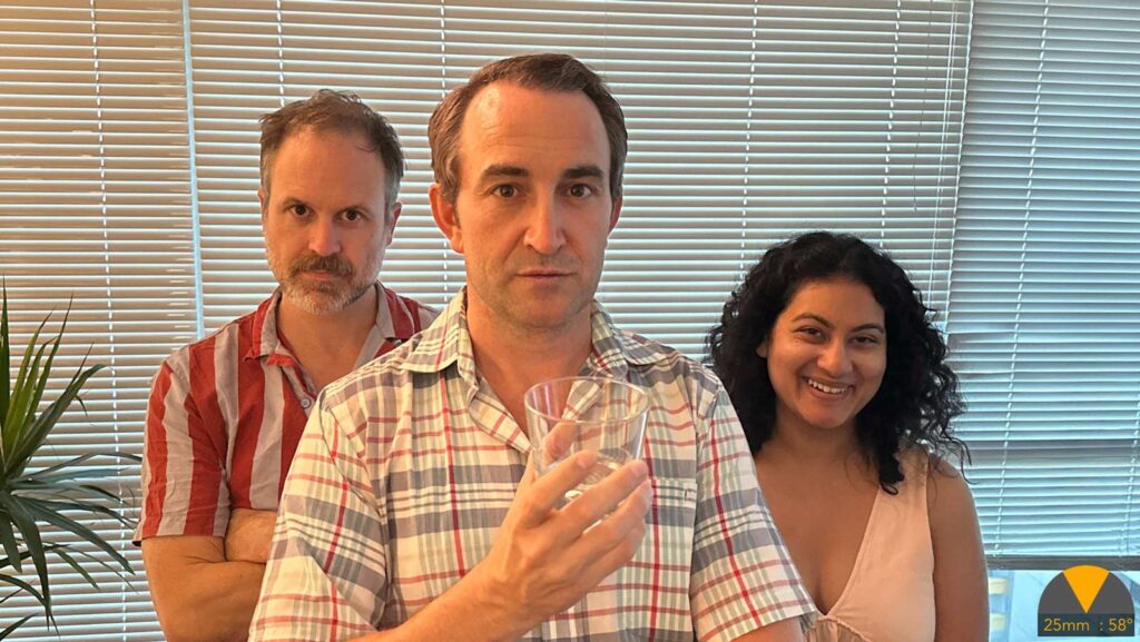 three people stand in front of lowered blinds