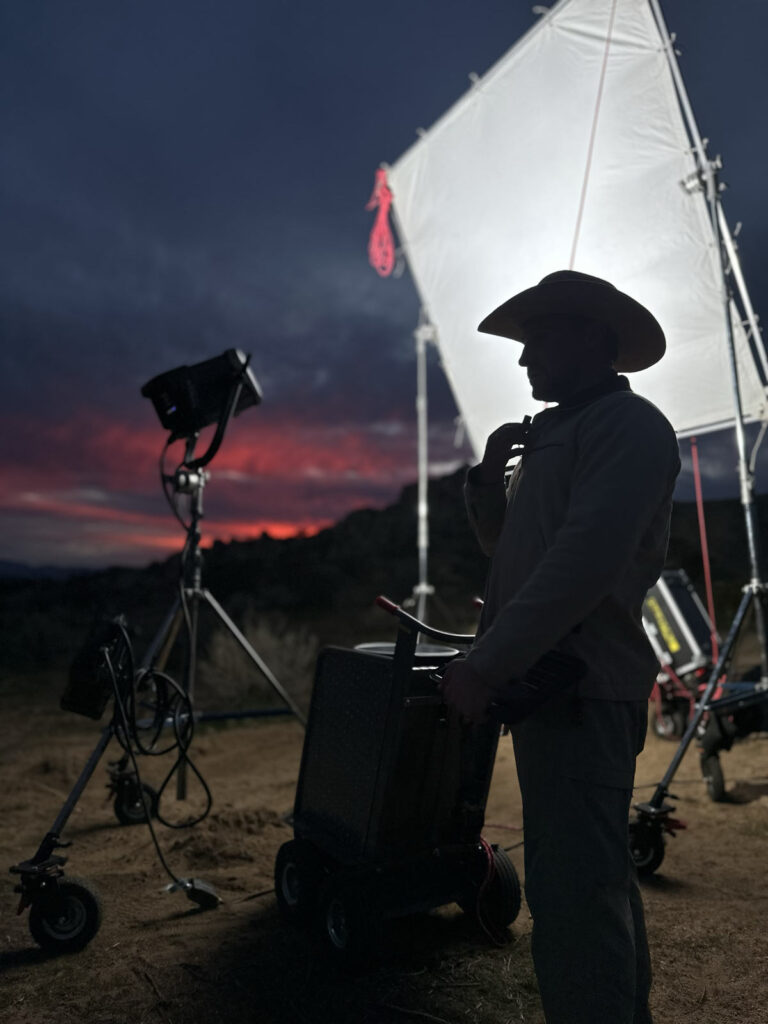 From the set of Illegal Aliens, Val Salembier stands in front of lighting gear