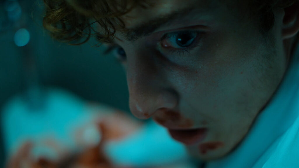 From Sick Days, a man looks over his shoulder with a bloody nose